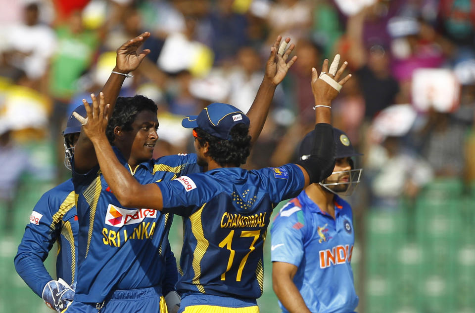 Sri Lanka’s Ajantha Mendis, second left, facing camera, celebrates with his teammates the wicket of India’s Virat Kohli, behind,during the Asia Cup one-day international cricket tournament in Fatullah, near Dhaka, Bangladesh, Friday, Feb. 28, 2014. (AP Photo/A.M. Ahad)
