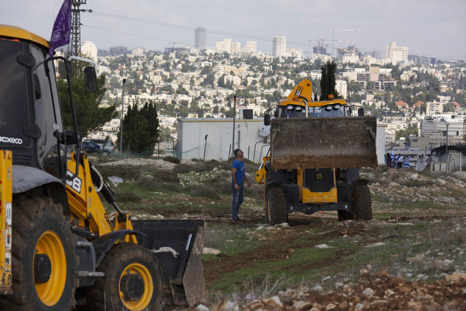 FILE - In this Nov. 16, 2020, file, photo, workers take a break before European Union officials visit the construction site for Givat Hamatos settlement in Jerusalem. Israel is quietly advancing controversial settlement projects in and around Jerusalem while refraining from major announcements that could anger the Biden administration. Critics say Israel is paving the way for rapid growth when the political climate changes. (AP Photo/Maya Alleruzzo, File)