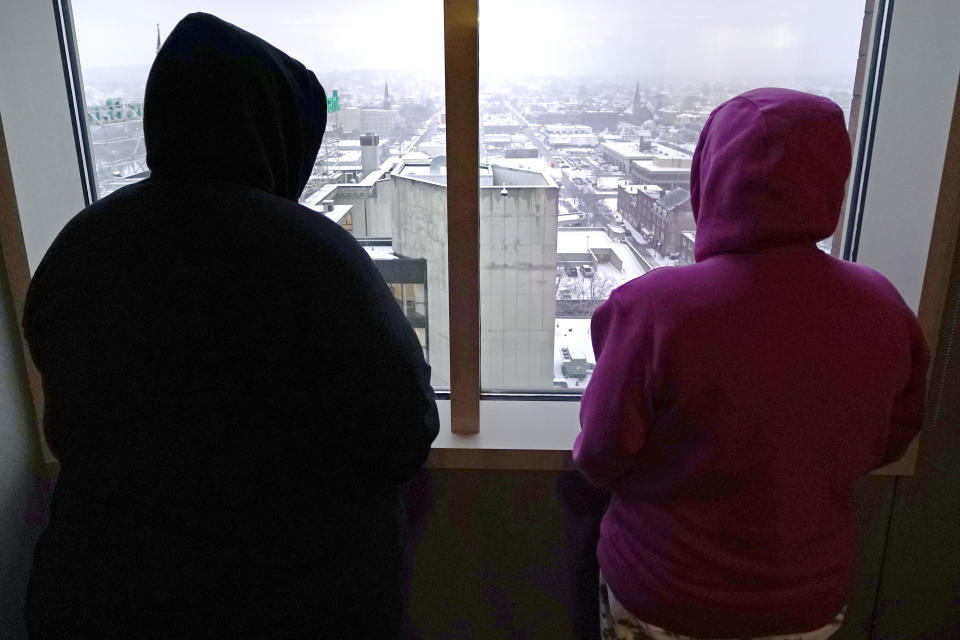 Two women, who allege abuse as minors by the ex-operations chief at New Hampshire's youth detention center, stand in their lawyer's office Thursday, Jan. 12, 2023, in Manchester, N.H. Twenty men and women say they were physically or sexually assaulted as children at New Hampshire's youth detention center by a man who went on to become the facility's chief of operations and later served on a committee advising the state on juvenile justice issues. (AP Photo/Charles Krupa)