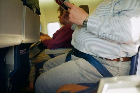 An overweight flier on a plane - Credit: Getty