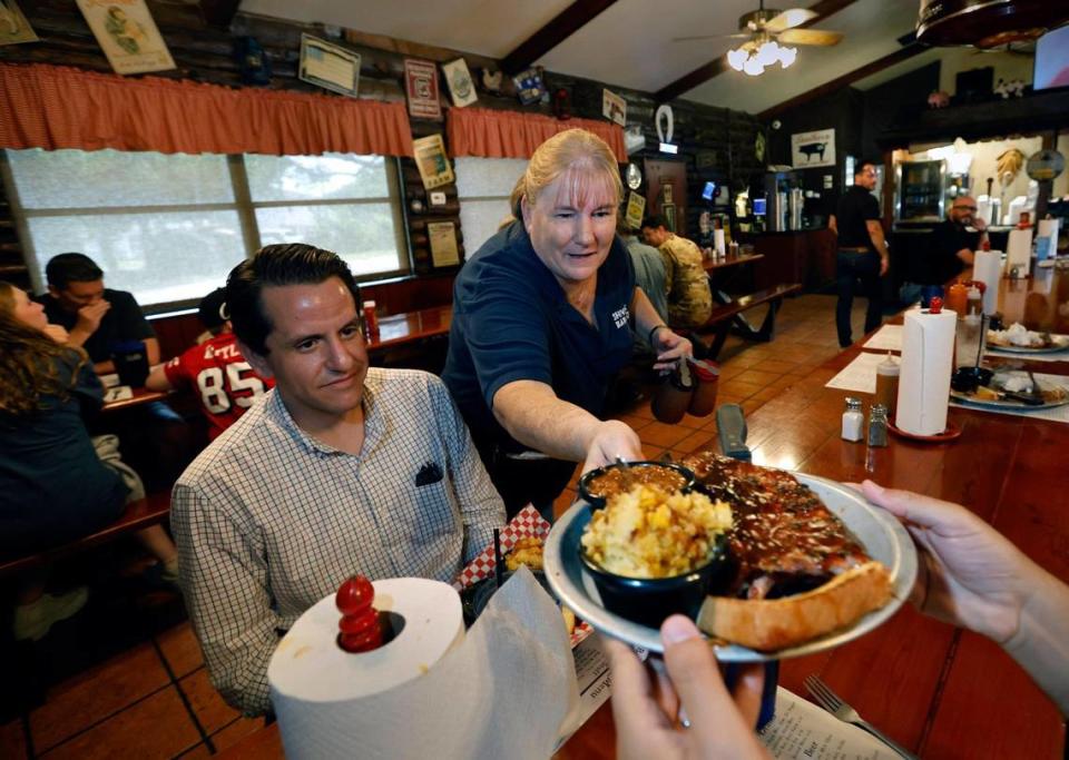 Manager Susan Fiorentino, who has worked at Shiver’s Bar-B-Q for almost 30 years, serves up a plate of ribs and sides to Manny Dieguez, at left, and Arturo Armand (who is reaching out for the plate).