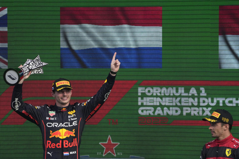 Red Bull driver Max Verstappen of the Netherlands lifts his trophy on the podium after winning the Formula One Dutch Grand Prix auto race as third placed Ferrari driver Charles Leclerc of Monaco, right, looks on, at the Zandvoort racetrack, in Zandvoort, Netherlands, Sunday, Sept. 4, 2022. (AP Photo/Peter Dejong)