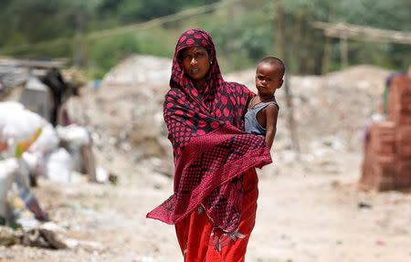 A woman from the Rohingya community walks through a camp in Delhi, India August 17, 2017. REUTERS/Cathal McNaughton/Files