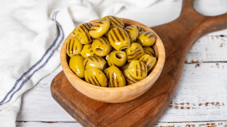 Grilled olives in wooden bowl