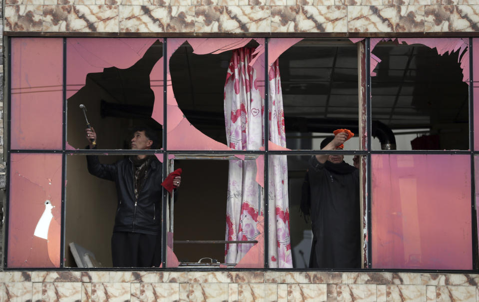 Afganos retiran los vidrios rotos de una ventaja en una casa afectada por la explosión de una bomba en Kabul, Afganistán, el 26 de febrero de 2020. (AP Foto/Rahmat Gul)