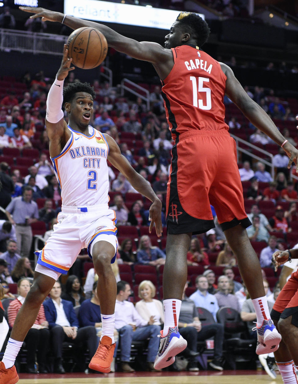 Oklahoma City Thunder guard Shai Gilgeous-Alexander (2) passes around Houston Rockets center Clint Capela during the first half of an NBA basketball game, Monday, Oct. 28, 2019, in Houston. (AP Photo/Eric Christian Smith)