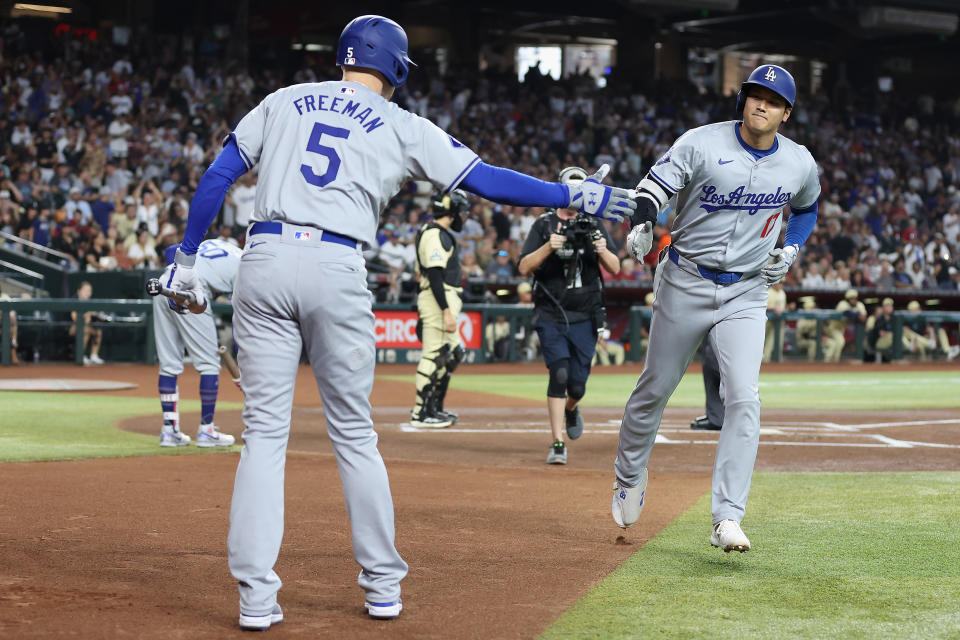 PHOENIX, ARIZONA - AUGUST 31: Shohei Ohtani #17 of the Los Angeles Dodgers high fives Freddie Freeman #5 after hitting a solo home run against the Arizona Diamondbacks during the first inning of the MLB game at Chase Field on August 31, 2024 in Phoenix, Arizona. (Photo by Christian Petersen/Getty Images)