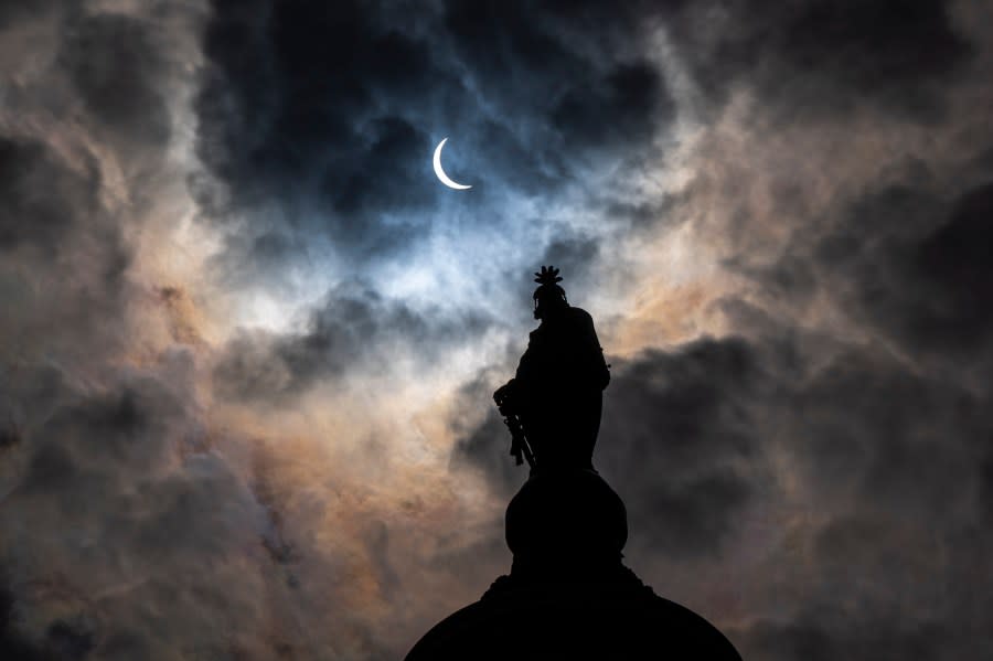 The Statue of Freedom on top of the U.S. Capitol stands as the moon partially covers the sun during a total solar eclipse, as seen from Capitol Hill, Monday, April 8, 2024, in Washington. (AP Photo/Alex Brandon)