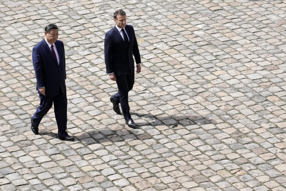 China's President Xi Jinping, left, and French President Emmanuel Macron walk during an official welcoming ceremony at the Hotel des Invalides monument, Monday, May 6, 2024 in Paris. China's President Xi Jinping is in France for a two-day state visit that is expected to focus both on trade disputes and diplomatic efforts to convince Beijing to use its influence to move Russia toward ending the war in Ukraine. (AP Photo/Christophe Ena)