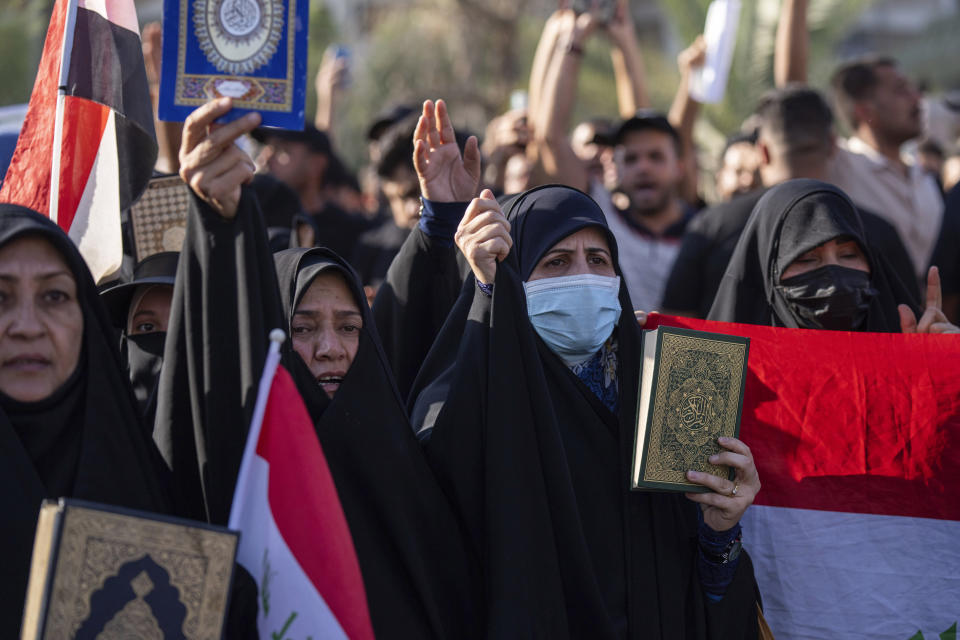 Supporters of Shiite Muslim leader Moqtada Sadr step on a LGBTQ+ rainbow flag in front of the Swedish embassy in Baghdad in response to the burning of Quran in Sweden, Baghdad, Iraq, Friday, June. 30, 2023. (AP Photo/Hadi Mizban)