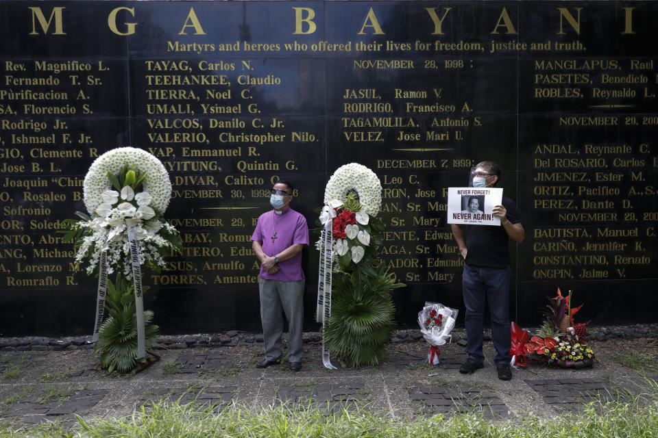 FILE - Protesters stand in front of a wall with names of martyrs and heroes who were the victims of the abuses of the Marcos dictatorship during a rally at the Bantayog ng mga Bayani, or Monument to the Heroes, to mark the 48th anniversary of the declaration of martial law on Sept. 21, 2020, in Quezon city, Philippines. Filipino voters overwhelmingly elected Ferdinand "Bongbong" Marcos Jr., as president during the May 2022 elections, completing a stunning return to power for the Marcos clan, which ruled the country for more than two decades until being ousted in 1986 in the nonviolent “People Power” revolution. (AP Photo/Aaron Favila, File)