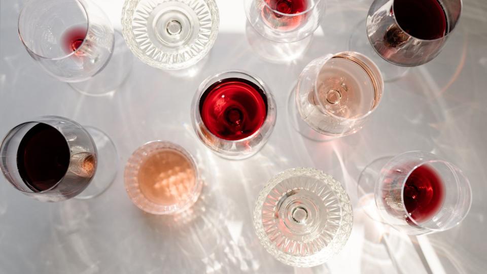 glasses of red white rose wine and wine bottle on the table shot from above