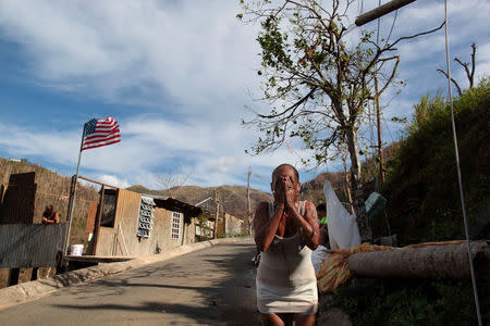 Ruth Santiago refreshes herself with water from a pipe after Hurricane Maria destroyed the town's bridge in San Lorenzo, Morovis, Puerto Rico, October 4, 2017. REUTERS/Alvin Baez