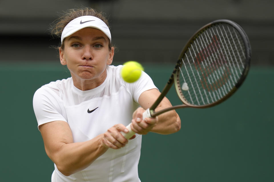 FILE - Romania's Simona Halep returns to Amanda Anisimova in a women's singles quarterfinal match on day ten of the Wimbledon tennis championships in London, Wednesday, July 6, 2022. Former No. 1-ranked player Simona Halep was provisionally suspended by the International Tennis Integrity Agency after failing a drug test during the U.S. Open last month. The ITIA announced the suspension Friday, Oct. 21, 2022, for Halep, a two-time Grand Slam champion who is currently No. 9 in the WTA rankings. (AP Photo/Kirsty Wigglesworth, File)