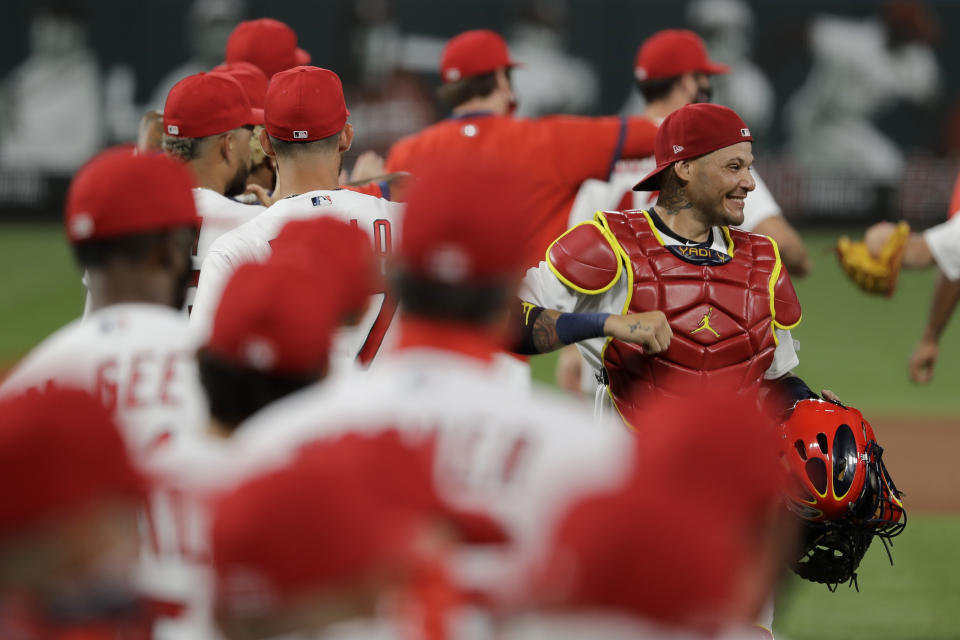 El cátcher de los Cardenales Yadier Molina (con pechera) festeja una victoria 5-4 sobre los Piratas en San Luis el 24 de julio del 2020. Los equipos de las grandes ligas están realizando rastreos internos para evitar la propagación del coronavirus. Los Cardenales, no obstante, tienen varios infectados. (AP Photo/Jeff Roberson)