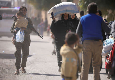 A woman holds her belongings as she flees Raqqa. REUTERS/Rodi Said