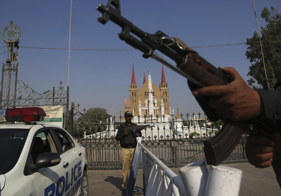 In this Tuesday, Oct. 30, 2018, photo Pakistani police officers stand guard outside Saint Patrick's Cathedral in Karachi, Pakistan. Synagogues, mosques, churches and other houses of worship are routinely at risk of attack in many parts of the world. And so worshippers themselves often feel the need for visible, tangible protection even as they seek the divine. (AP Photo/Shakil Adil)