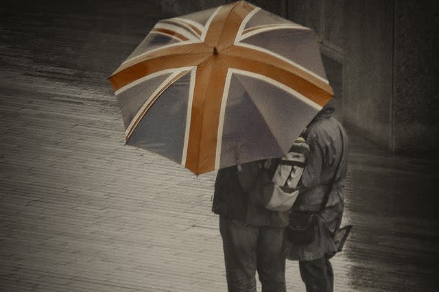 A couple of tourist walking in London under the rain.