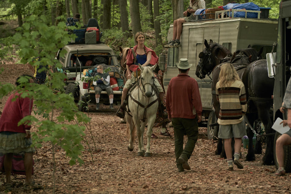 Mackenzie Davis riding horseback in a caravan in Station Eleven