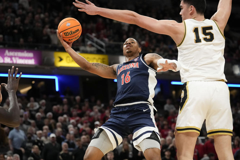 Arizona forward Keshad Johnson (16) shoots around Purdue center Zach Edey (15) in the first half of an NCAA college basketball game in Indianapolis, Saturday, Dec. 16, 2023. (AP Photo/AJ Mast)