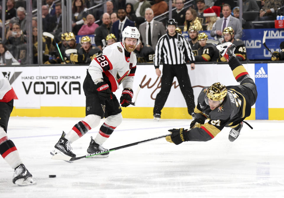 Vegas Golden Knights center Brett Howden (21) falls in front of Ottawa Senators right wing Claude Giroux (28) during the third period of an NHL hockey game Sunday, Dec. 17, 2023, in Las Vegas. (AP Photo/Steve Marcus)