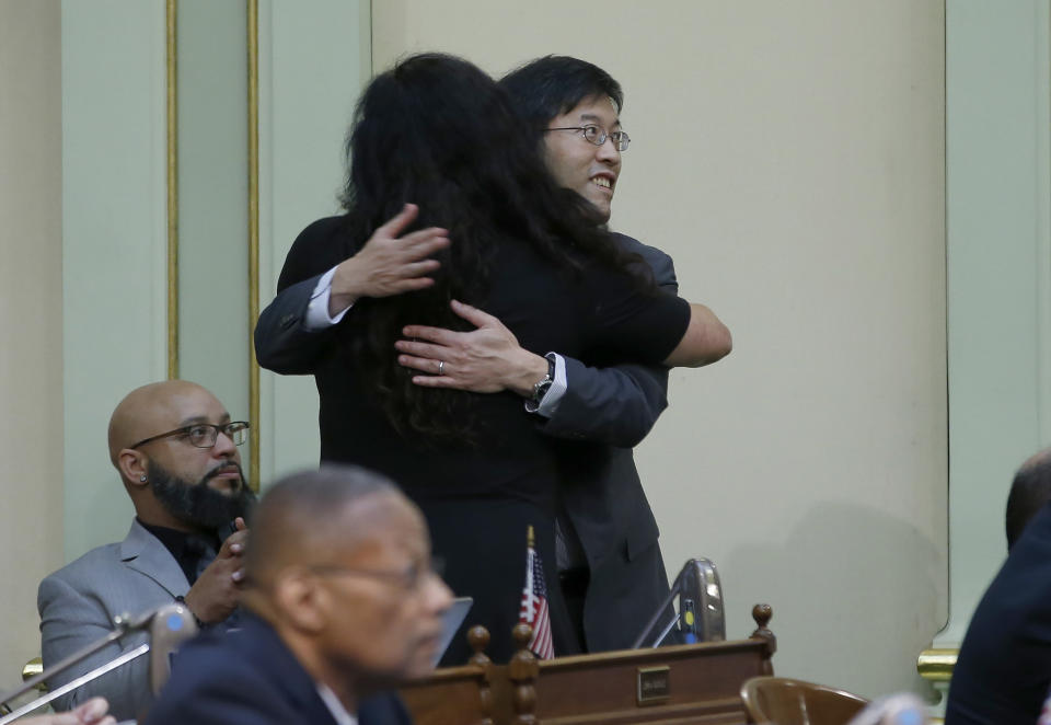 State Sen. Richard Pan, D-Sacramento, is hugged by Assemblywoman Lorena Gonzalez, D-San Diego, to tighten the rules on giving exemptions for vaccinations was approved by the Assembly in Sacramento, Calif., Tuesday, Sept. 3, 2019. The bill SB276, would give state public health officials oversight of doctors who give more than five medical exemptions annually and schools with vaccination rates less than 95%. It still needs a final approval in the state Senate. (AP Photo/Rich Pedroncelli)