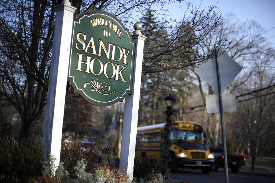 FILE - A bus drives past a sign reading, "Welcome to Sandy Hook," in Newtown, Conn., Dec. 4, 2013. A federal judge on Thursday, Aug. 3, 2023, rejected a request to temporarily block Connecticut's landmark 2013 gun control law, passed after the Sandy Hook Elementary School shooting, until a gun rights group's lawsuit against the statute has concluded. (AP Photo/Jessica Hill, File)