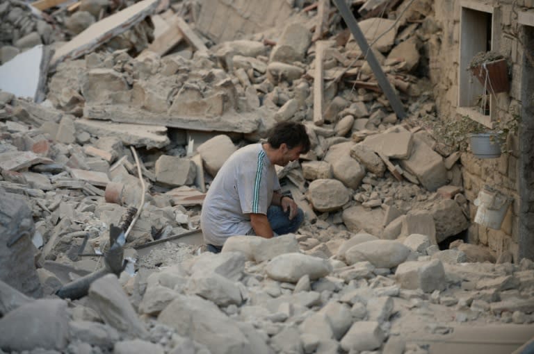 A man reacts to his damaged home after a strong earthquake hit Amatrice on August 24, 2016