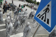 <p>Performance artists covered in clay to look like zombies walk over a crosswalk trance-like through the city center on July 5, 2017 in Hamburg, Germany. (Friedemann Vogel/Getty Images) </p>