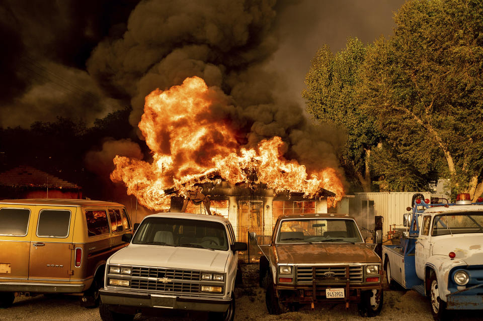 Flames consume a home as the Sugar Fire, part of the Beckwourth Complex Fire, tears through Doyle, Calif., on Saturday, July 10, 2021. Pushed by heavy winds amid a heat wave, the fire came out of the hills and destroyed multiple residences in central Doyle. (AP Photo/Noah Berger)