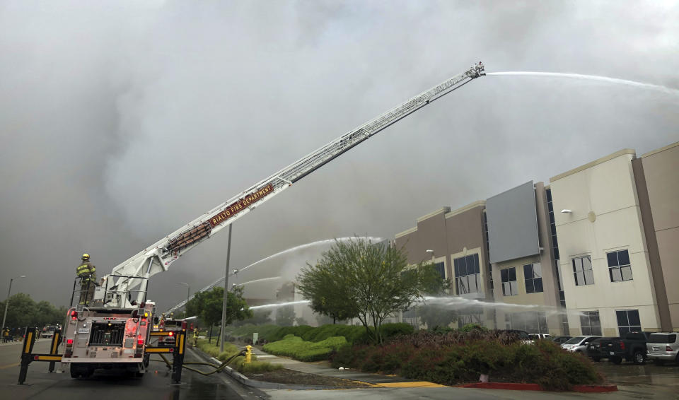 Firefighters from multiple agencies battle a warehouse fire in Redlands, Calif., on Friday, June 5, 2020. The destroyed a huge commercial building, about 60 miles east of Los Angeles, but there are no reports of injuries.(Watchara Phomicinda/The Orange County Register via AP)