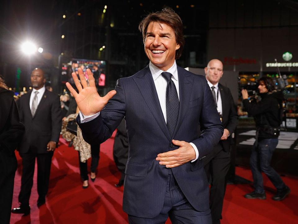 Tom Cruise waiving on a red carpet.