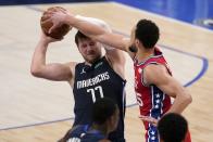 Dallas Mavericks guard Luka Doncic (77) works to keep control of the ball against Philadelphia 76ers guard Ben Simmons (25) in the first half of an NBA basketball game in Dallas, Monday, April 12, 2021. (AP Photo/Tony Gutierrez)