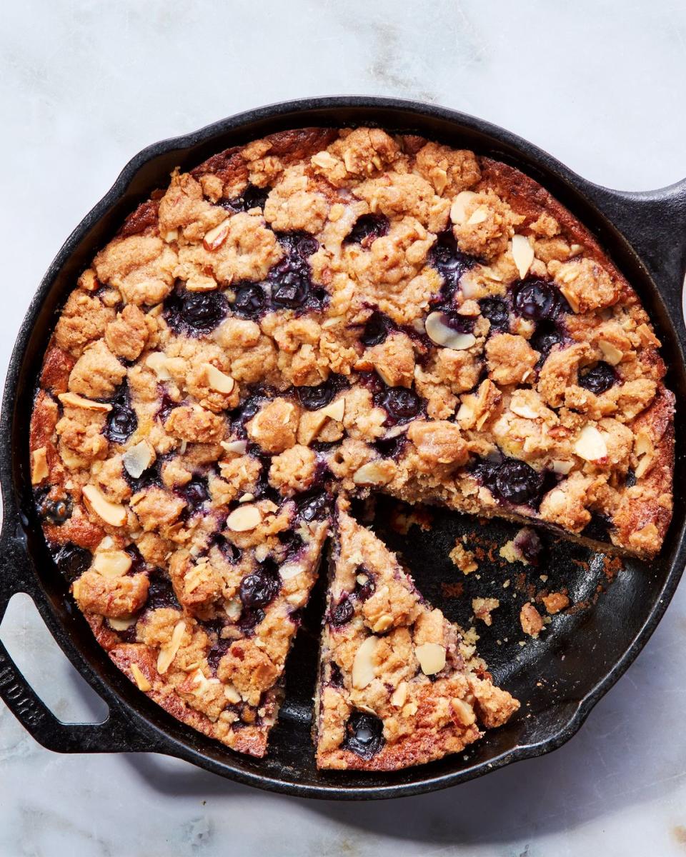 blueberry cake in a skillet topped with a crumble