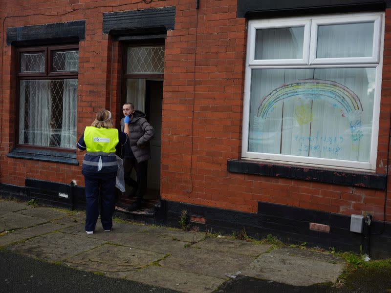 A member of the community swabbing team carries out a doorstep COVID-19 testing following the outbreak of the coronavirus disease (COVID-19) in Chadderton, Britain