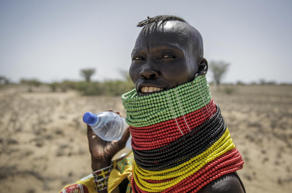 A woman carries a bottle of water as she walks back from a trading center towards her village of Lomoputh in northern Kenya Thursday, May 12, 2022. United Nations Under-Secretary-General for Humanitarian Affairs Martin Griffiths visited the area on Thursday to see the effects of the drought which the U.N. says is a severe climate-induced humanitarian emergency in the Horn of Africa. (AP Photo/Brian Inganga)