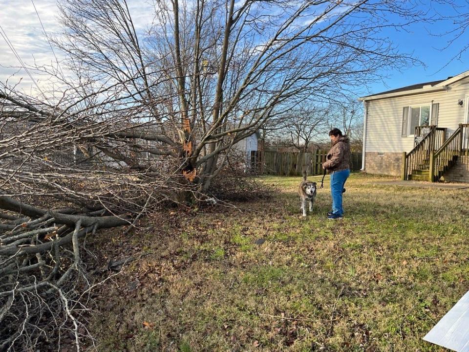 Amber Gannon stands outside her home, which narrowly missed tornado damage that destroyed a nearby auto-parts store.