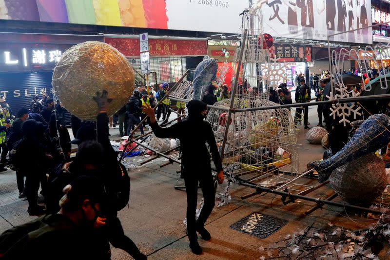 Anti-government protesters tear down Christmas and New Year's decorations during a demonstration on New Year's Eve outside Mong Kok police station in Hong Kong