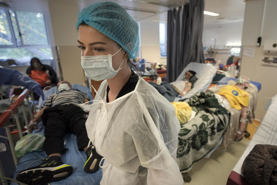 FILE - A member of the medical staff walks in a crowded COVID-19 isolation room at the University Emergency Hospital in Bucharest, Romania, Friday, Oct. 22, 2021. This was supposed to be the Christmas in Europe where family and friends could once again embrace holiday festivities and one another. Instead, the continent is the global epicenter of the COVID-19 pandemic as cases soar to record levels in many countries. (AP Photo/Vadim Ghirda, File)