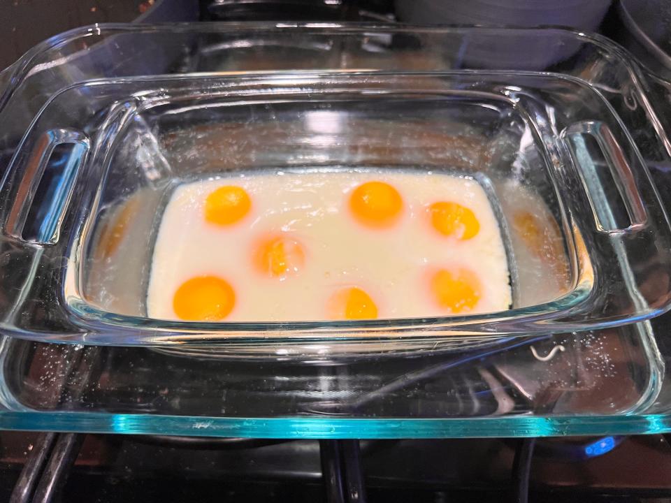 baked eggs in a loaf pan resting in a larger baking dish filled with water