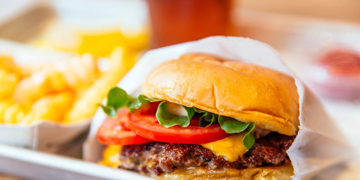 close up of juicy cheeseburger with fresh tomatoes