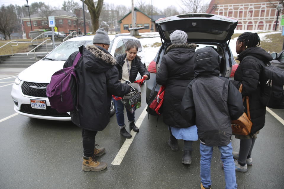 Monica Pineda Etter, second from left, helps a Haitian family load their belongings into her car on Thursday March 23, 2023 in St. Johnsbury, Vt. Pineda Etter was among a number of local officials and volunteers who worked to provide the family the services they need to help them on their way to Miami. The U.S. Border Patrol says agents are releasing some immigrants who were apprehended in Vermont after they entered the country illegally and dropping them off where they can find public transportation. (AP Photo/Wilson Ring)