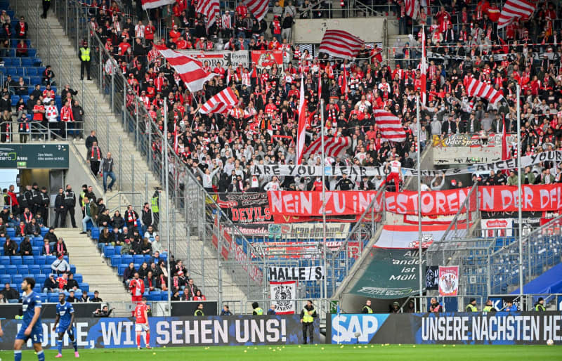 Union Berlin fans repeatedly throw tennis balls onto the pitch in protest against the German Football League's (DFL) plans to bring in investors during the German Bundesliga soccer match between TSG 1899 Hoffenheim and 1. FC Union Berlin at the PreZero Arena. Jan-Philipp Strobel/dpa