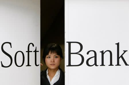 A worker at an electronics store opens a door printed with the logo of Softbank Corp, Japan's third-biggest wireless carrier, in Tokyo October 29, 2008. REUTERS/Kim Kyung-Hoon/File Photo