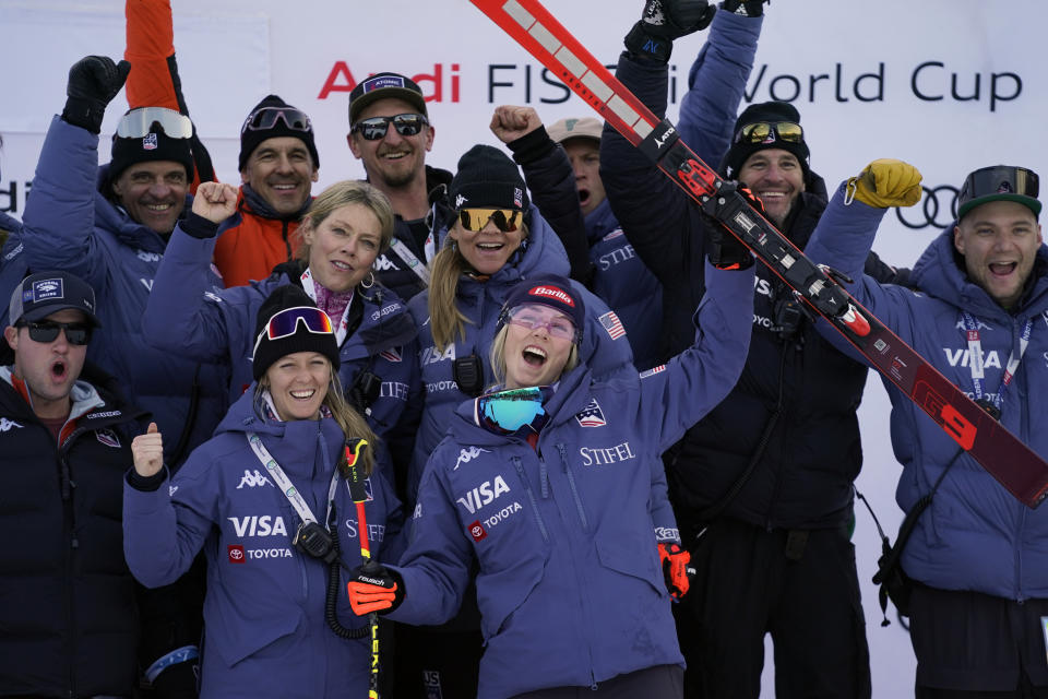 United States' Mikaela Shiffrin, foreground center, celebrates with the team after winning an alpine ski, women's World Cup giant slalom race, in Lienz, Austria, Thursday, Dec. 28, 2023. (AP Photo/Giovanni Auletta)