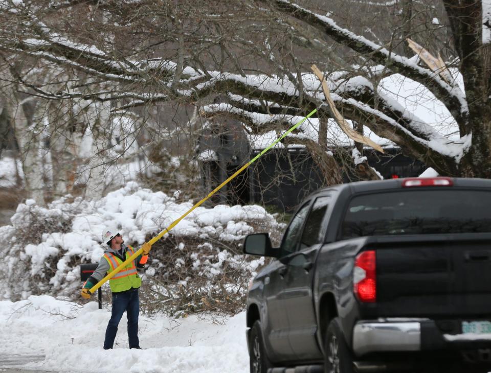 A lineman clears hanging limbs in a Dover Point neighborhood Wednesday, Jan. 25, 2023.