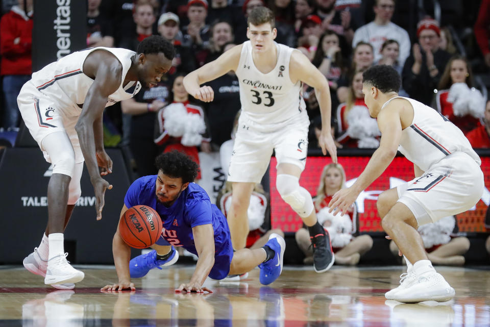 SMU's Isiah Jasey, below, loses control of the ball next to Cincinnati's Mamoudou Diarra, left, during the first half of an NCAA college basketball game Tuesday, Jan. 28, 2020, in Cincinnati. (AP Photo/John Minchillo)