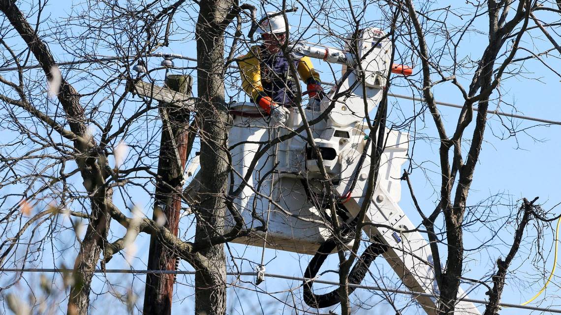 A Kentucky Utilities employee works on a power line off St. Ives Circle Saturday, March 4, 2023 in Lexington, Ky. A strong wind storm the night before knocked out power to much of Lexington, Ky.