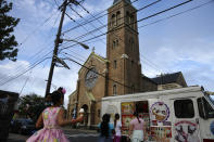 In this May 28, 2020, photo, people buy ice cream across the street from St. Nicholas Church in Jersey City, N.J. Mitchell Garabedian, an attorney for two alleged victims of Roman Catholic Bishop Nicholas DiMarzio, told the Associated Press that Samier Tadros, 46, stepped forward after hearing that another man, 57-year-old Mark Matzek, had accused DiMarzio of sexually abusing him in the mid-1970s, when he was assigned to St. Nicholas Church. Joseph Hayden, DiMarzio’s attorney, said he has evidence showing the accusations made by both men are false. (AP Photo/Jessie Wardarski)