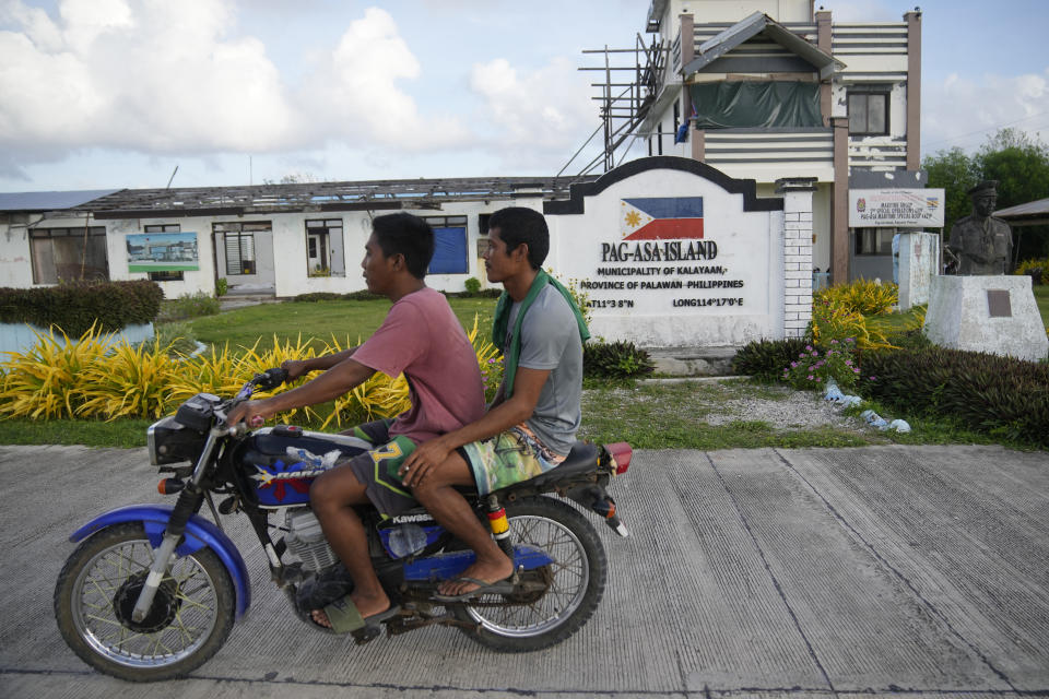 Residents ride a motorcycle at the Philippine-occupied Thitu island, locally called Pag-asa island, on Friday, Dec. 1, 2023 at the disputed South China Sea. The Philippine coast guard inaugurated a new monitoring base Friday on a remote island occupied by Filipino forces in the disputed South China Sea as Manila ramps up efforts to counter China's increasingly aggressive actions in the strategic waterway. (AP Photo/Aaron Favila)